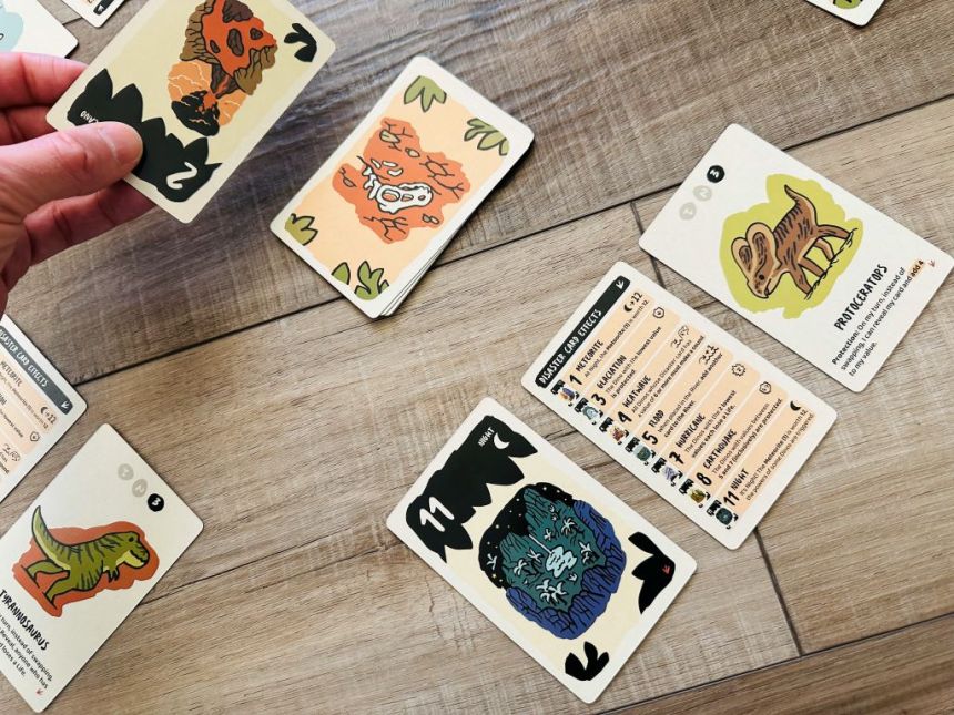 Hand putting down card next to dck in Very Bad Lands