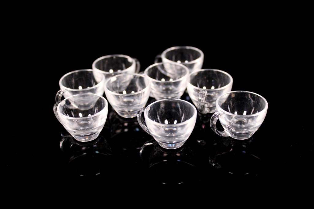 A collection of small, transparent cups arranged on a dark surface.