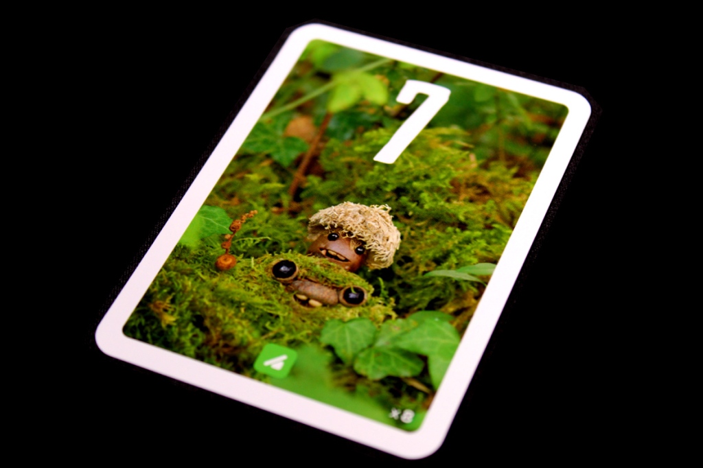 A card from the game Pixies featuring two small, whimsical creatures in a green mossy environment with the number 7 displayed prominently.