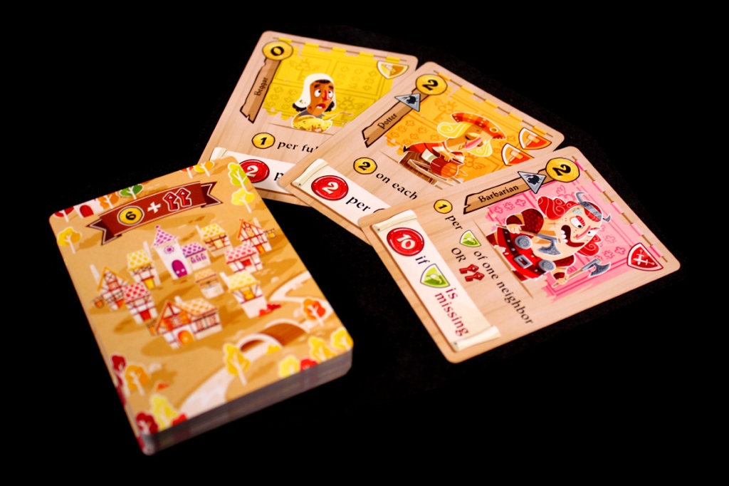 An assortment of game cards from Castle Combo, featuring whimsical artwork including buildings and characters, displayed on a black background.